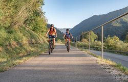 Die sanften Hügel der Ybbstaler Alpen laden zu einer erfrischenden Radtour ein. Zwei Radfahrer genießen die klare Bergluft und die malerische Landschaft, während sie auf dem gut ausgebauten Radweg entlangfahren. Umgeben von üppigem Grün und majestätischen Bergen ist dies der perfekte Ort, um die Schönheit der Natur zu erleben.