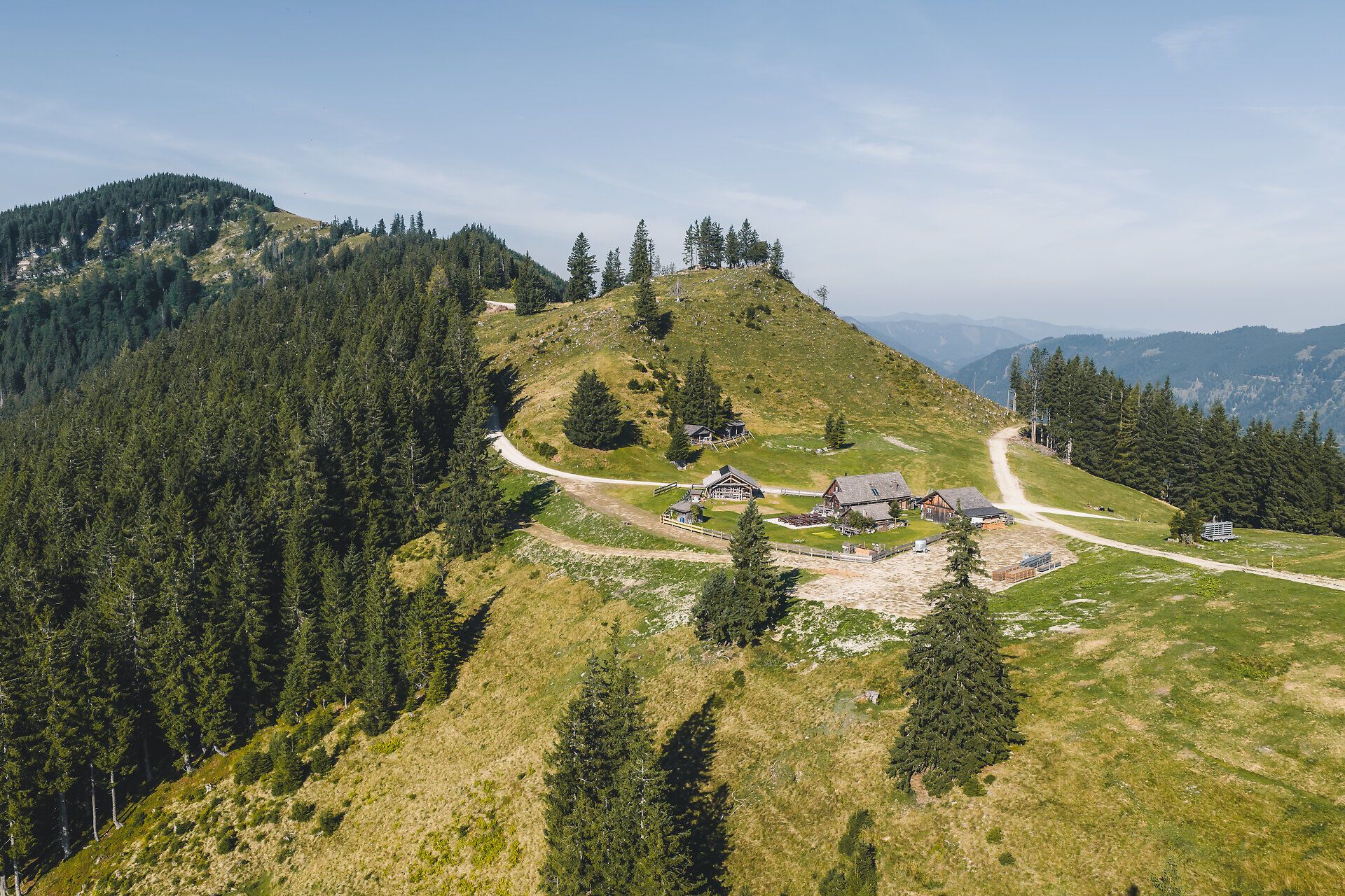 Luftaufnahme einer Berghütte vor einem Hügelrücken auf der Siebenhütten-Alm bei Göstling an der Ybbs.