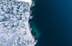 Die winterliche Landschaft verzaubert mit einer schimmernden Schneedecke, die die Bäume in ein glitzerndes Kleid hüllt. Der ruhige See spiegelt die kühle, klare Luft wider und lädt zu einem besinnlichen Spaziergang ein. Hier, wo die Natur in ihrer reinsten Form erstrahlt, findet jeder Besucher einen Ort der Ruhe und Erholung.
