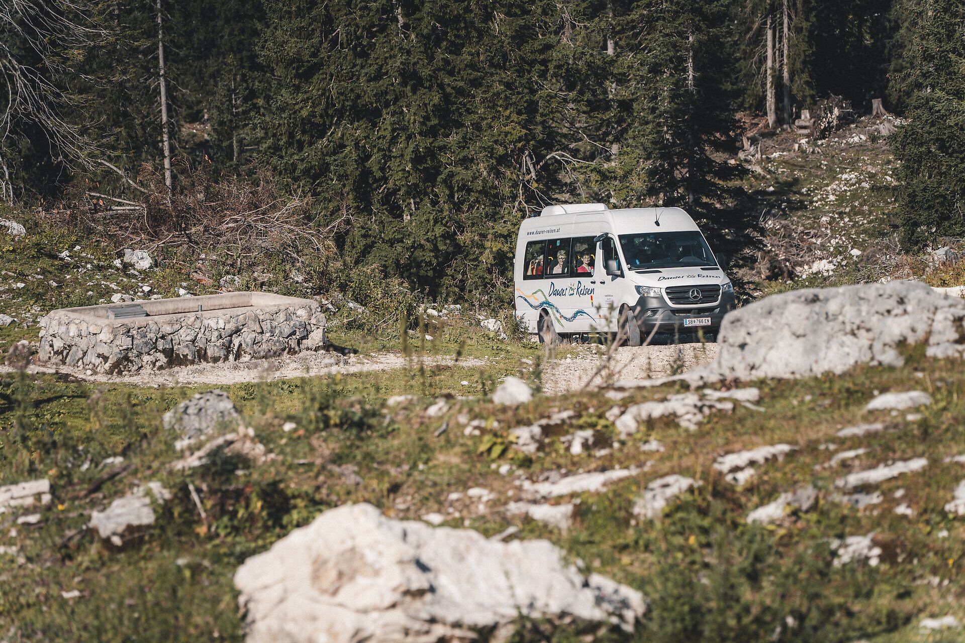 Wandertaxi fährt auf steiniger Straße auf die Schwarzalm.