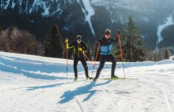 Zwei Langläufer gleiten elegant über die schneebedeckten Pisten, umgeben von der majestätischen Winterlandschaft des Ötschers. Die klare, kalte Luft und die glitzernden Schneekristalle schaffen eine zauberhafte Atmosphäre, die zum Verweilen einlädt. Hier, wo die Natur in ihrer reinsten Form erstrahlt, wird der Winter zum unvergesslichen Erlebnis.