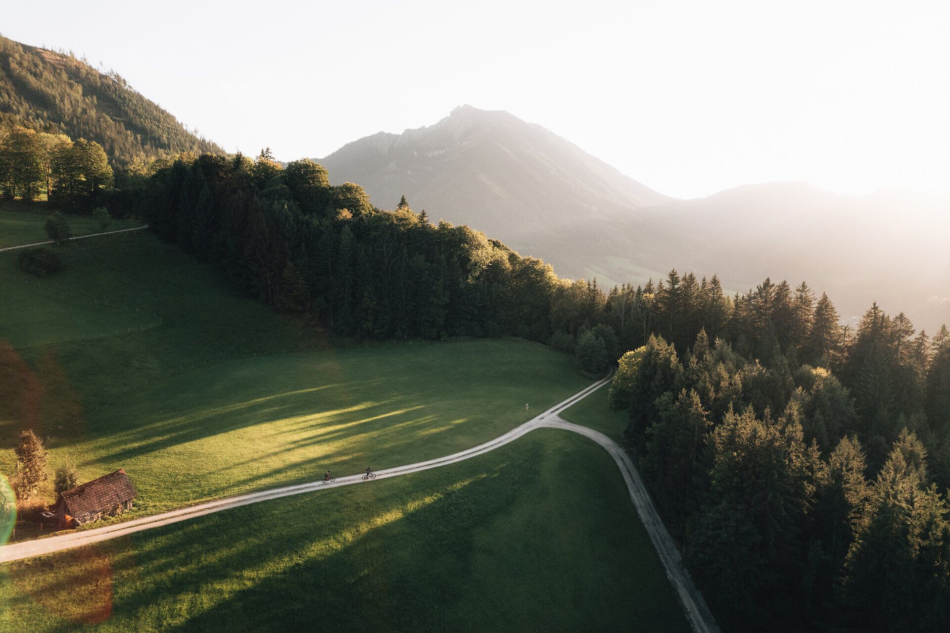 Die sanften Hügel und dichten Wälder laden zu unvergesslichen Mountainbike-Abenteuern ein. Die goldenen Strahlen der Abendsonne tauchen die Landschaft in ein warmes Licht und schaffen eine harmonische Atmosphäre, die zum Verweilen einlädt.