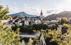 Das Bild zeigt Waidhofen an der Ybbs. Im Hintergrund ist ein hoher Kirchturm sowie die Mostviertler Bergwelt zu sehen.