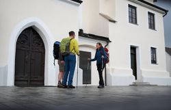 Pilgernde stehen vor Kirche entlang des Via Trinitatis Pilgerwegs.