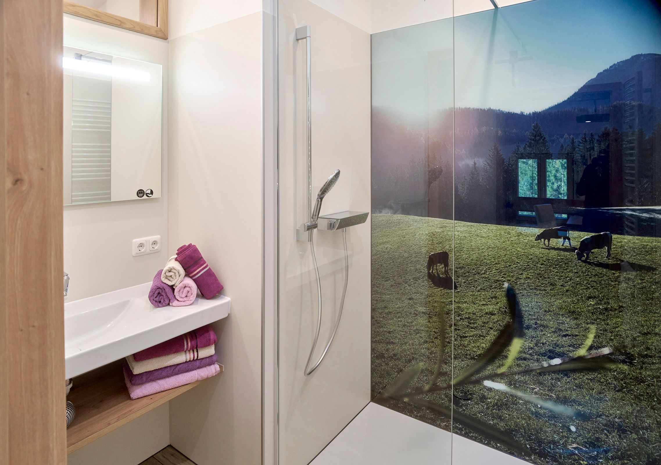 Modernes Badezimmer mit Dusche und Landschaftsbild auf der Duschwand.