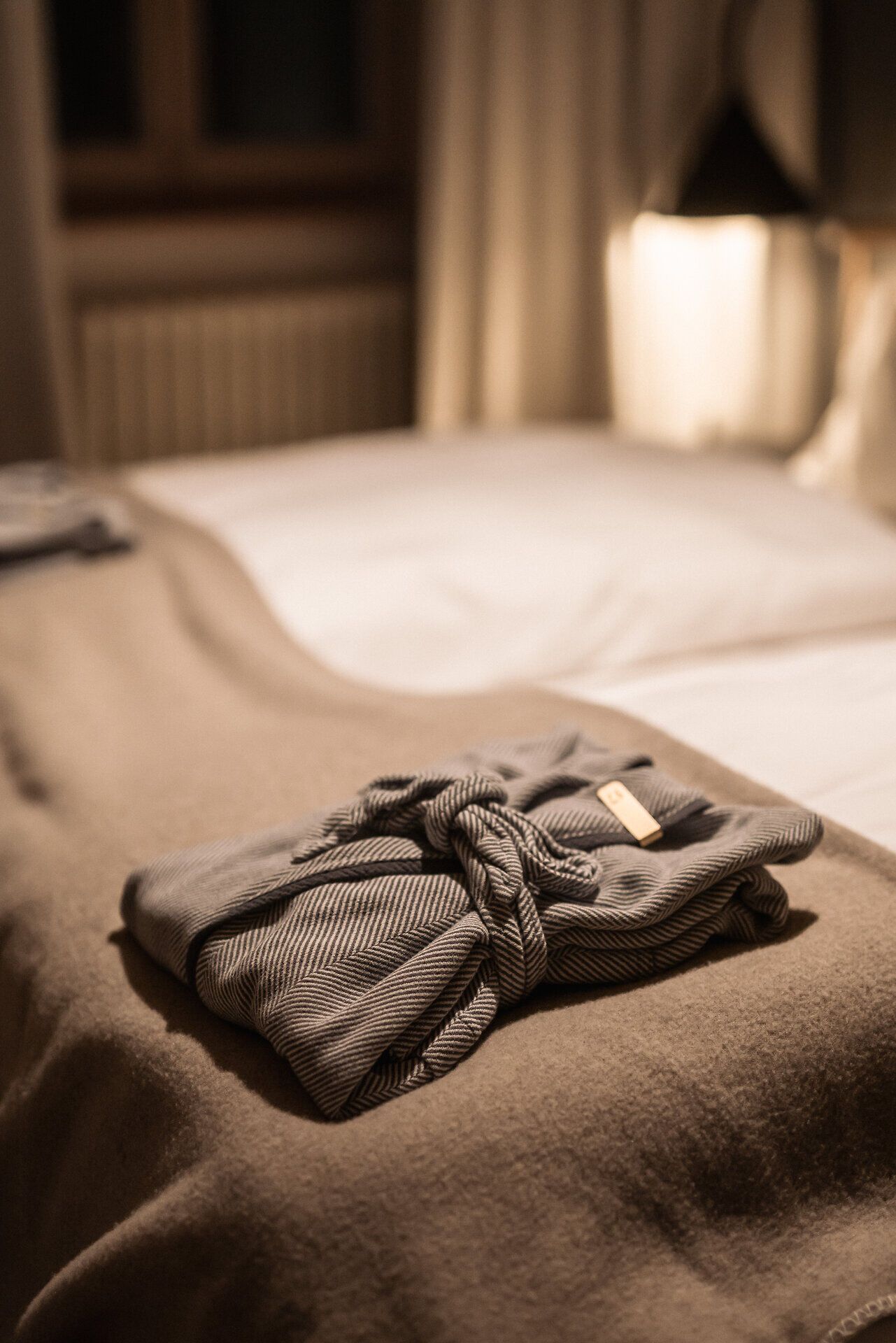 Gestreifter Bademantel liegt auf einem Bett im Refugium Lunz