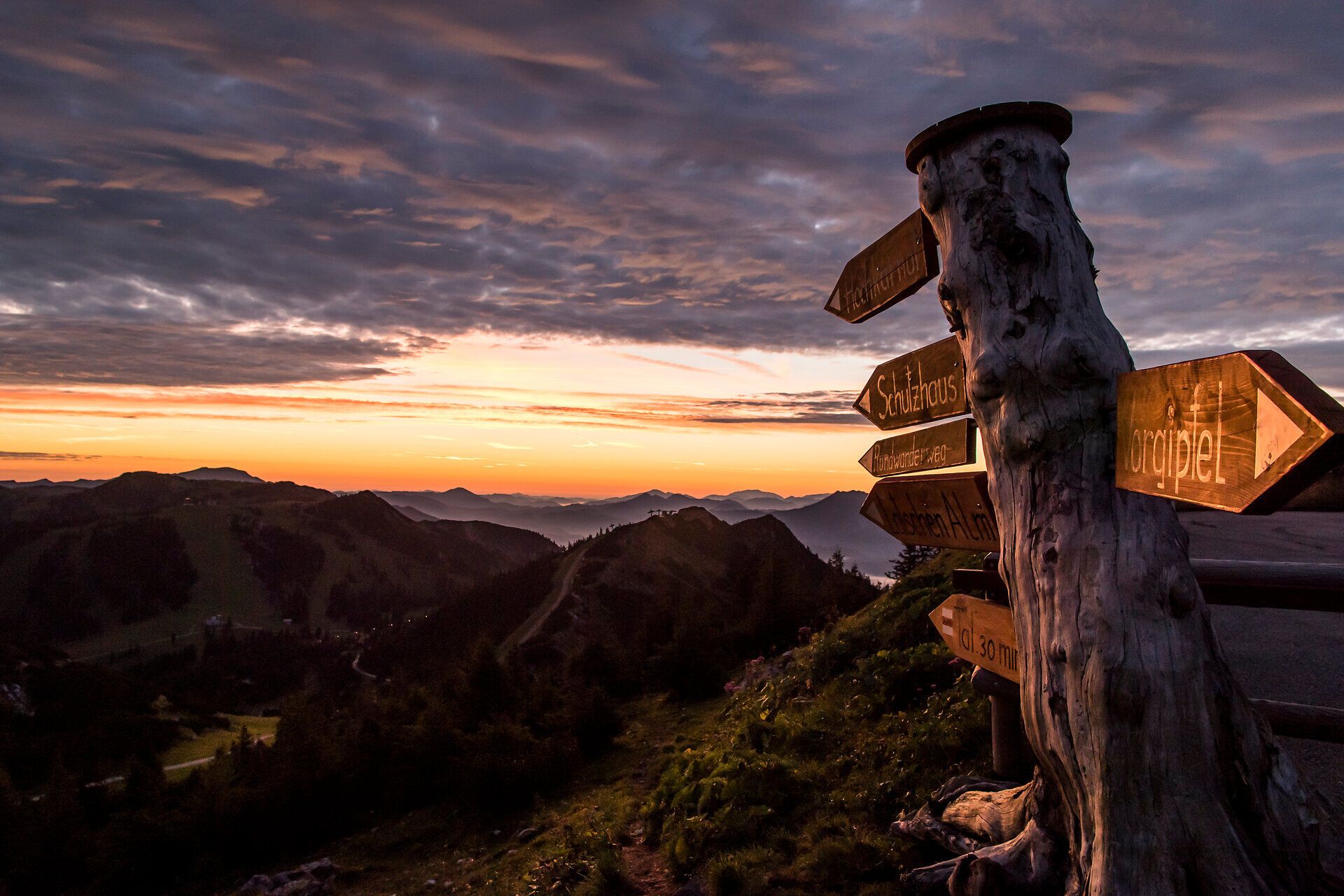 Der Sonnenuntergang über den majestätischen Bergen schafft eine magische Atmosphäre, während die letzten Strahlen des Tages die Landschaft in warmes Licht tauchen. Die sanften Hügel und die klaren Wege laden zu einem unvergesslichen Abenteuer ein, das die Seele berührt.