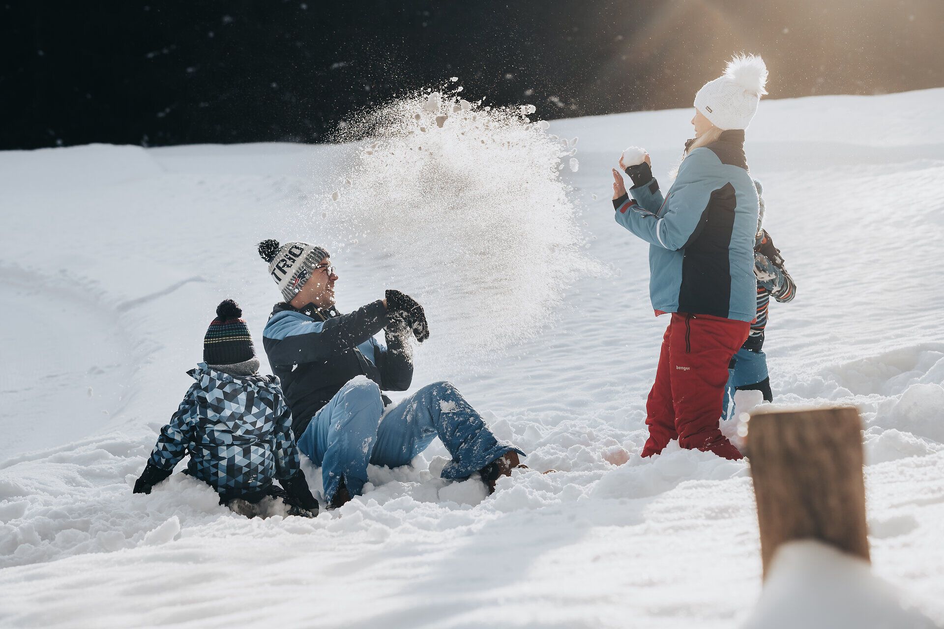 Eine fröhliche Familie genießt den Winter in den Ybbstaler Alpen, während sie sich in einer lebhaften Schneeballschlacht vergnügt. Die glitzernde Schneedecke und die strahlende Sonne schaffen eine magische Atmosphäre, die zum Lachen und Spielen einlädt.