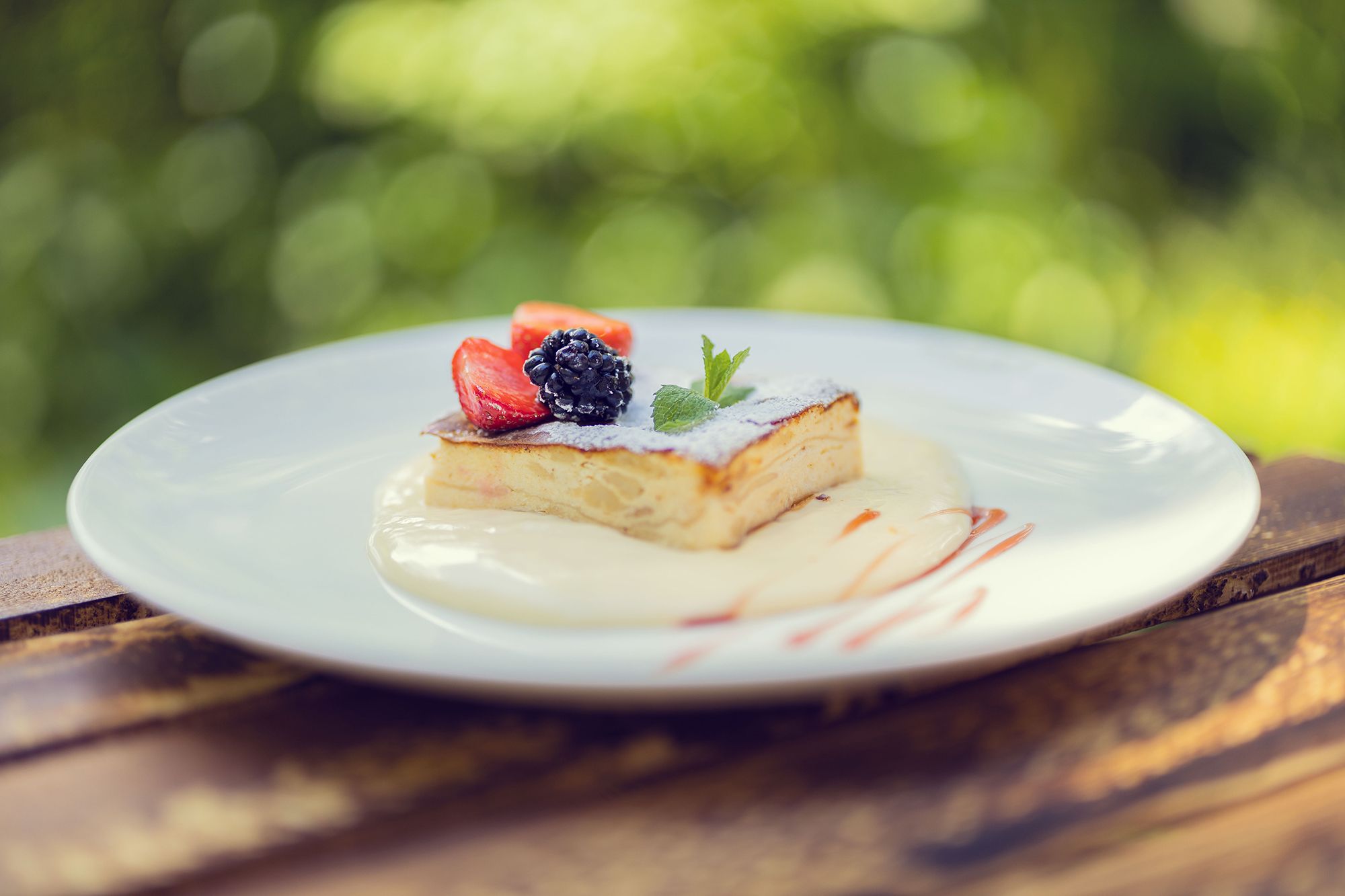 Ein Dessert mit Beeren auf einem Teller im Freien.