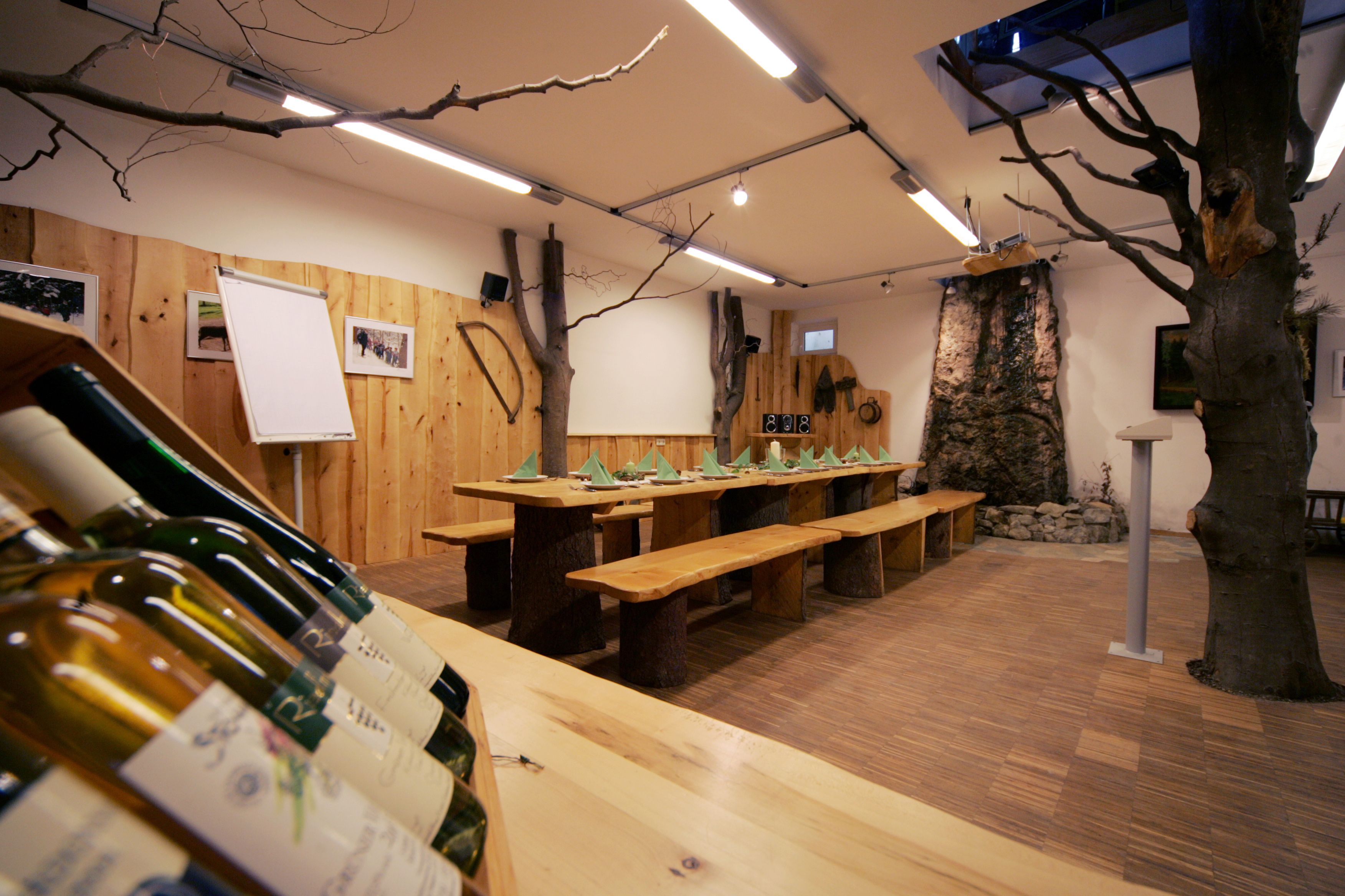 Gemütliches Naturparkhaus mit Holztisch, einem Baum im Zimmer und warmem Holzinterieur.