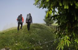 Pilgergruppe wandert entlang eines Hügelrückens.
