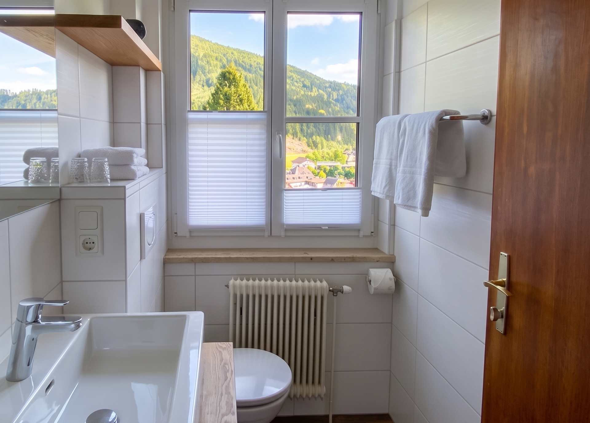 Modernes Badezimmer mit Fensterblick auf eine grüne Landschaft.