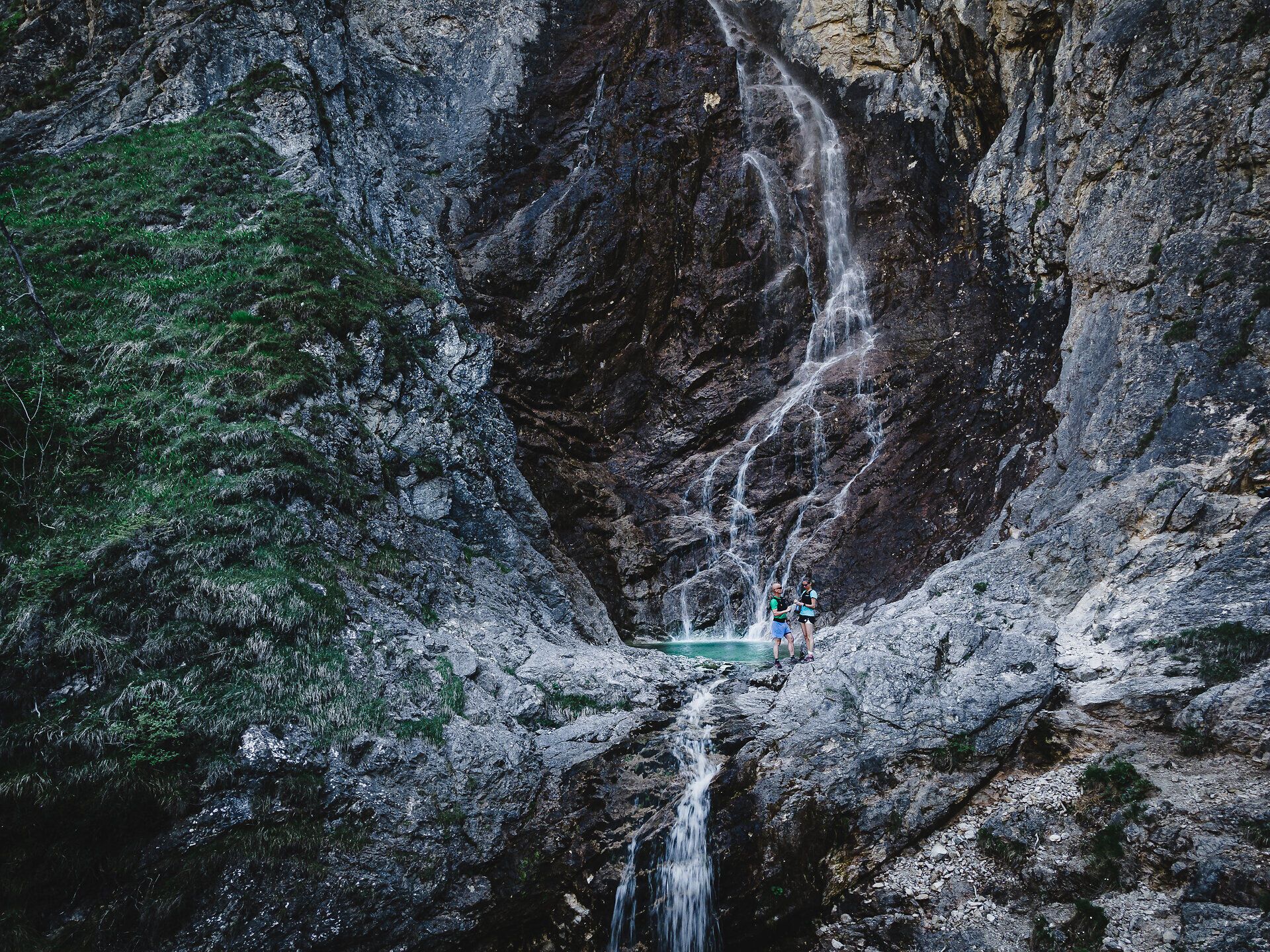 Ein erfrischender Wasserfall stürzt über die Felsen und schafft eine magische Atmosphäre inmitten der unberührten Natur. Die umliegenden grünen Wiesen und die majestätischen Berge laden dazu ein, die Schönheit des Bergsommers zu genießen und die Seele baumeln zu lassen.